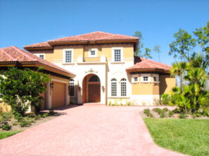 Here's an alt tag for the image: `Large, Mediterranean-style house with red tile roof`